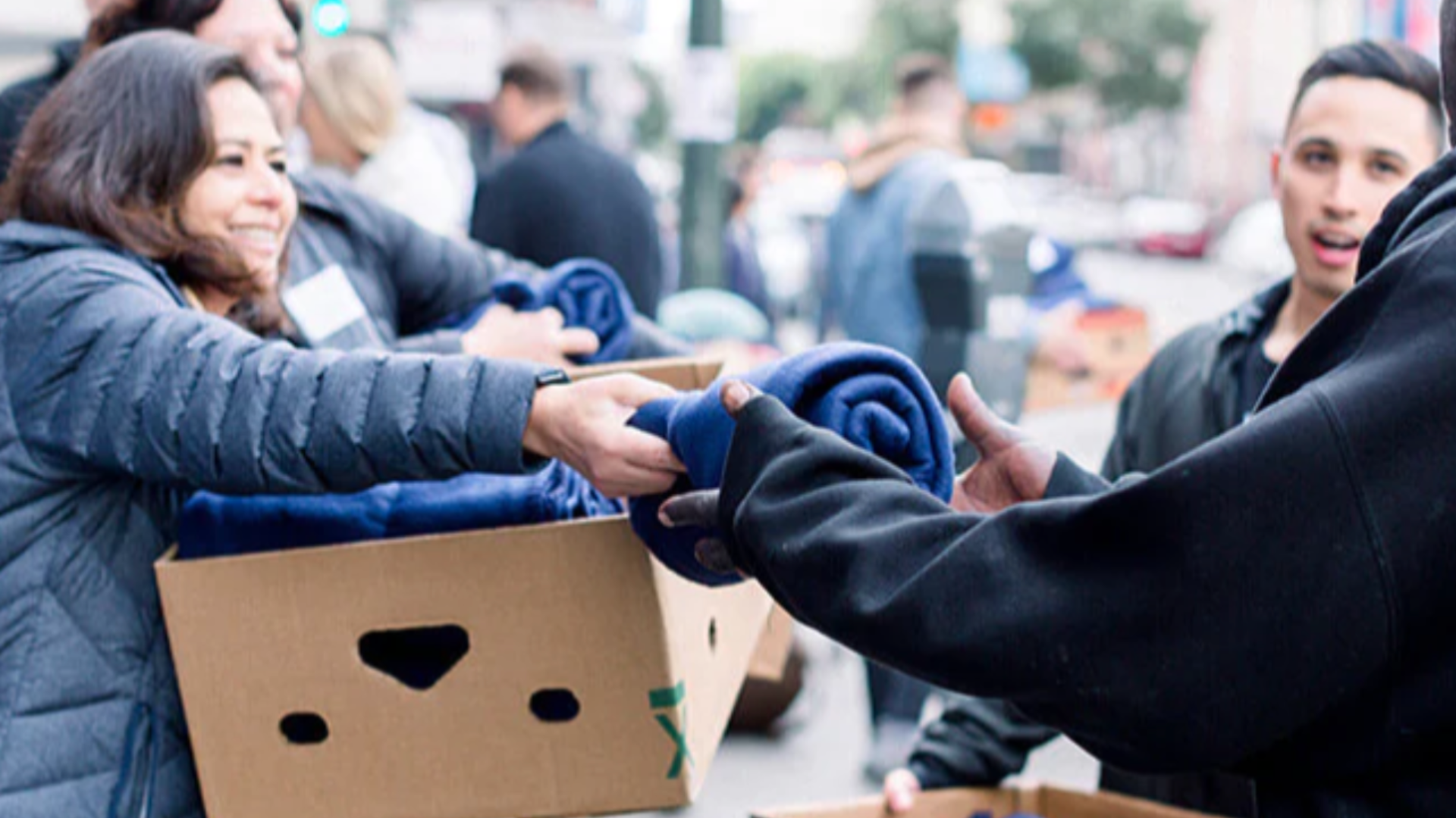 Community members distributing blankets together